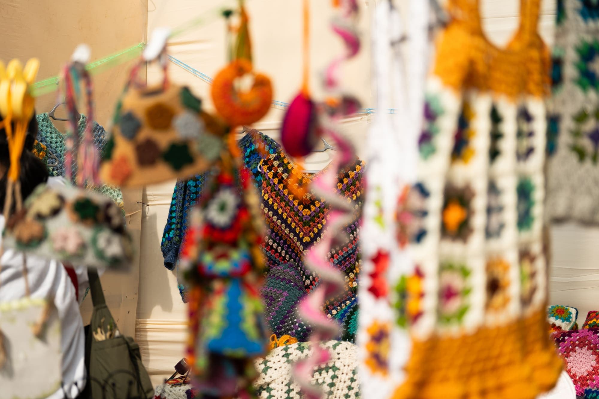 Crocheted bags and toys hanging at a craft stall